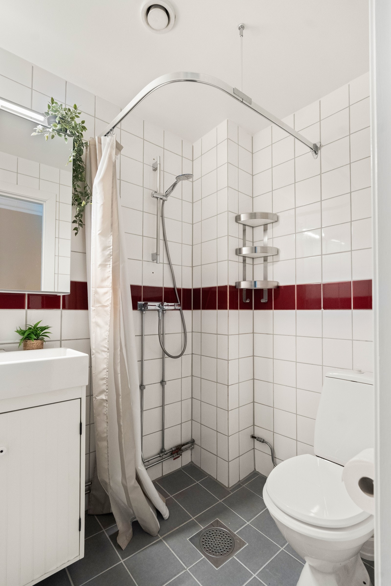 Baderom med flislagte overflater og malt tak. Galleribilde