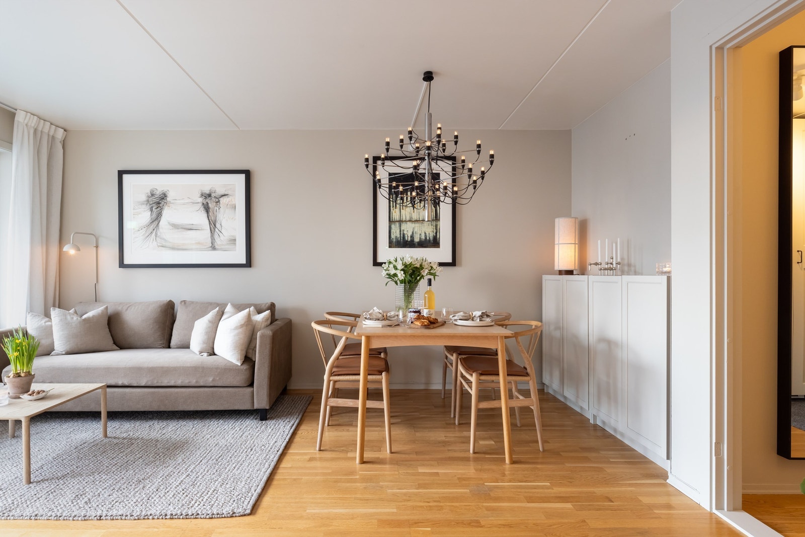 Leiligheten har en innbydende stue med plass til både sofa og stort spisebord. Galleribilde