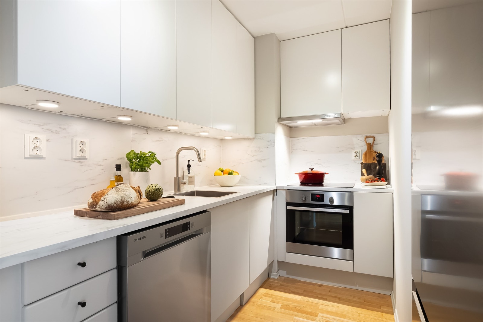 Delikat og innholdsrikt kjøkken som er plassert i en delvis åpen løsning mot stuen. Her er det godt med skap og benkeplass. Galleribilde