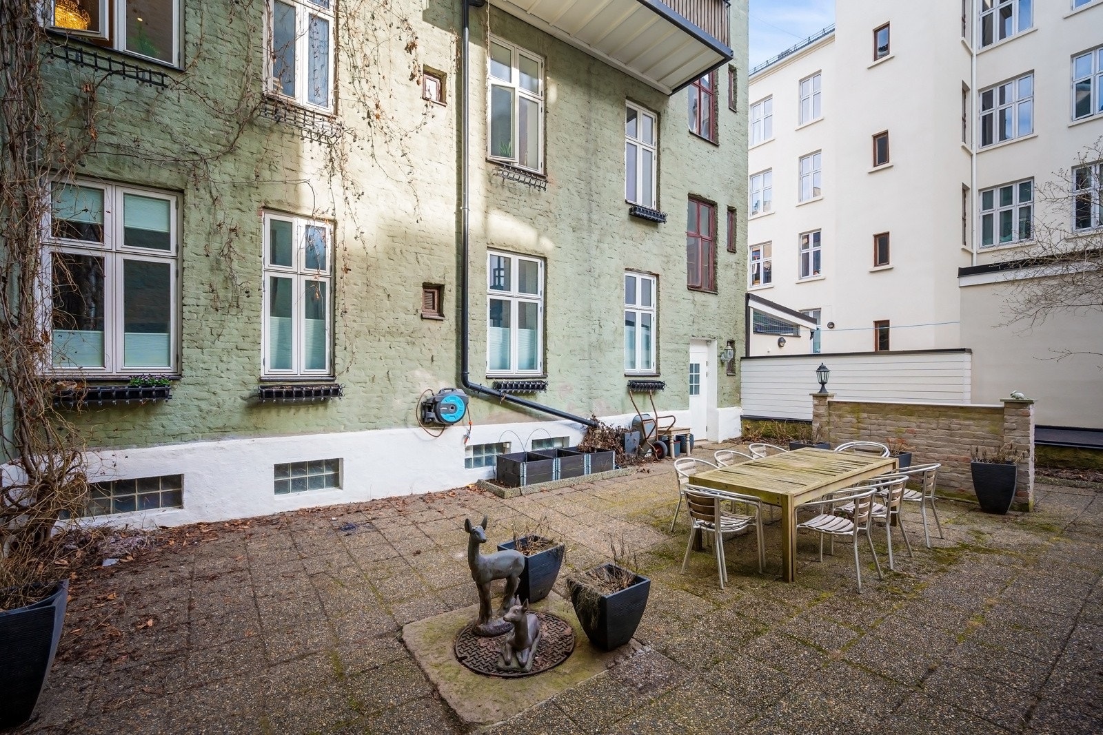 Bakgården er opparbeidet med sitteplasser og beplantning. Galleribilde