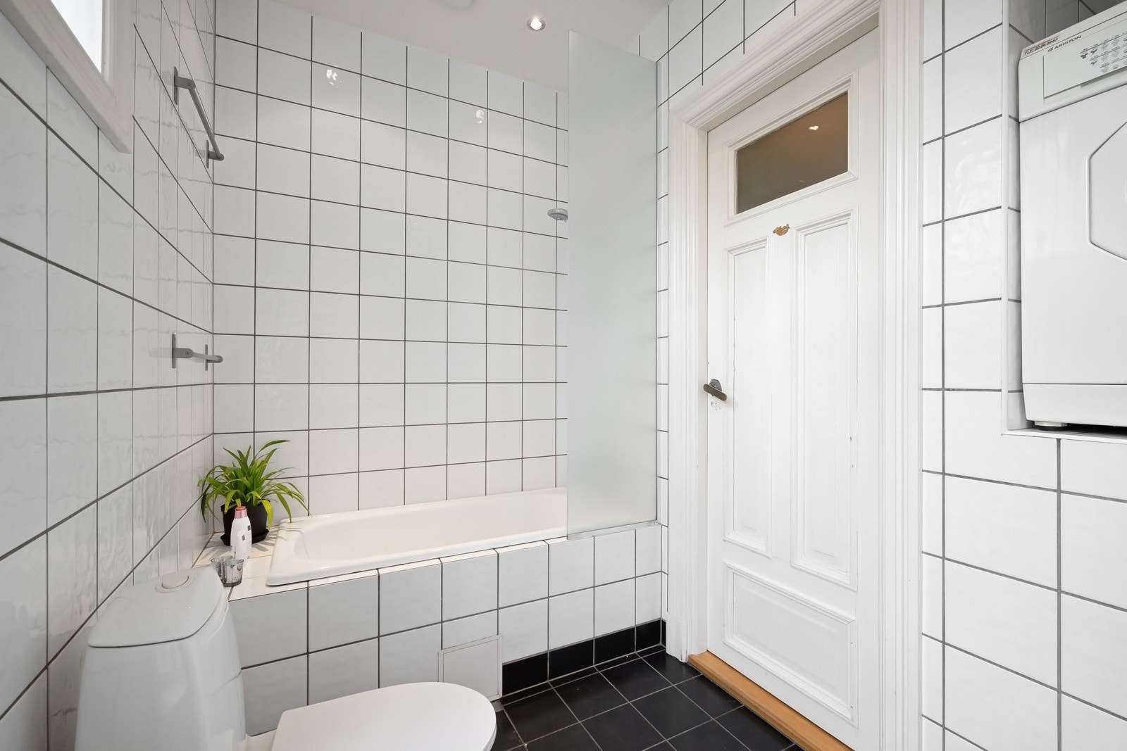 Badet er utstyrt med badekar med dusj, toalett, servant med innredning og speil. Det er også opplegg for vaskemaskin. Galleribilde