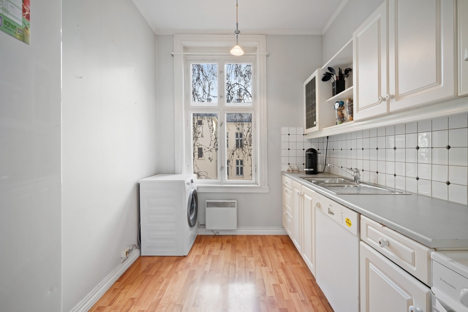 Boligens kjøkken vender i dag inn mot rolig bakgård. Kjøkkeninnredningen har profilerte fronter og benkeplate i laminat. Galleribilde