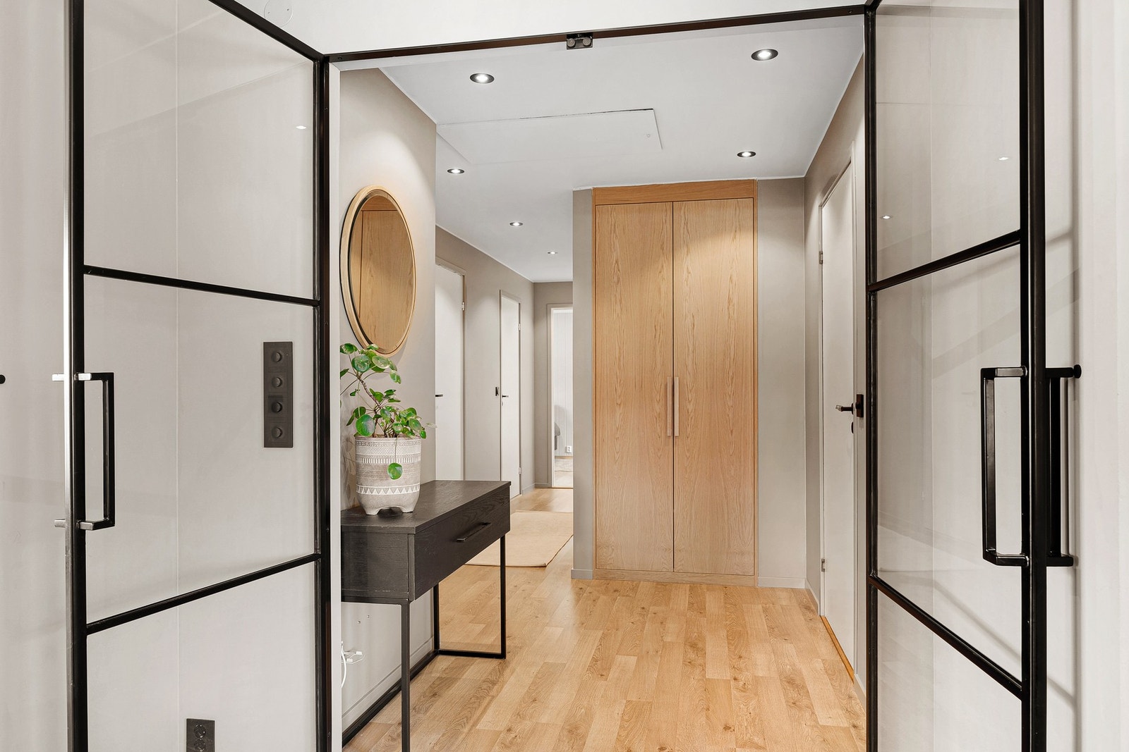 Stuen er adskilt fra gang med doble smijernsdører, som må sies å være et møbel i seg selv. Glassene slipper rikelig med lys inn i gang. Galleribilde