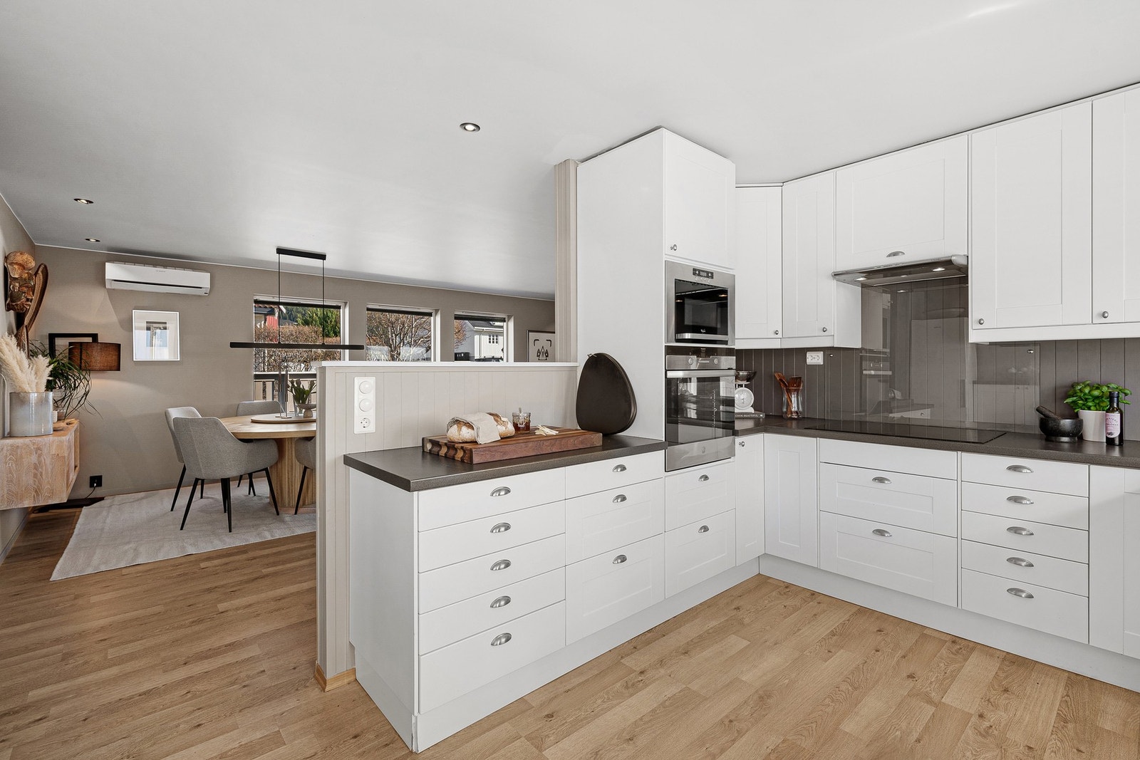 Mange vil sette pris på at kjøkkenet er delvis adskilt fra stuen. Praktisk med hvitevarer i høyskap. Galleribilde