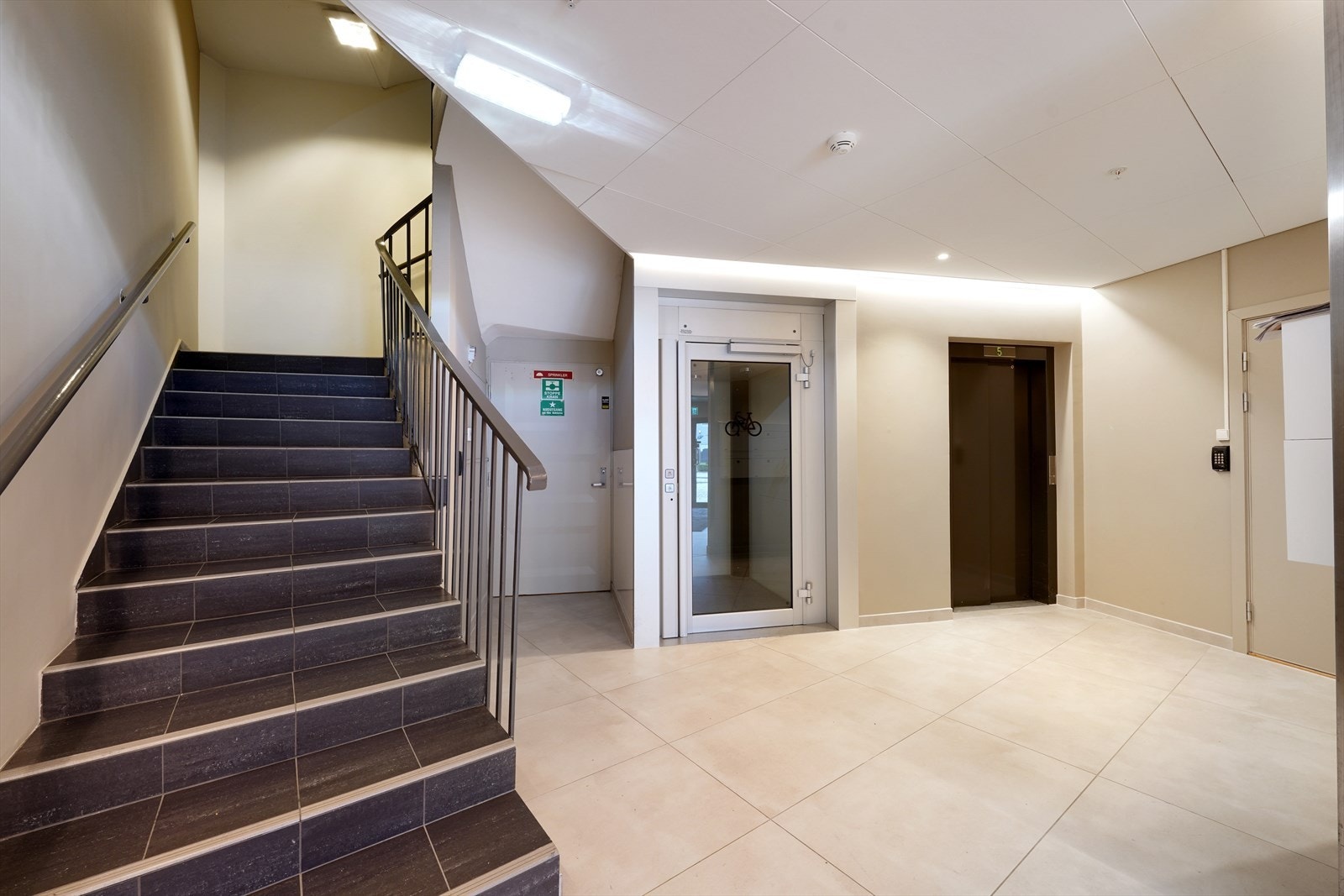 Lys og innbydende inngangsparti med både trapp og heis, gir enkel tilgang til alle etasjer i bygget. Galleribilde