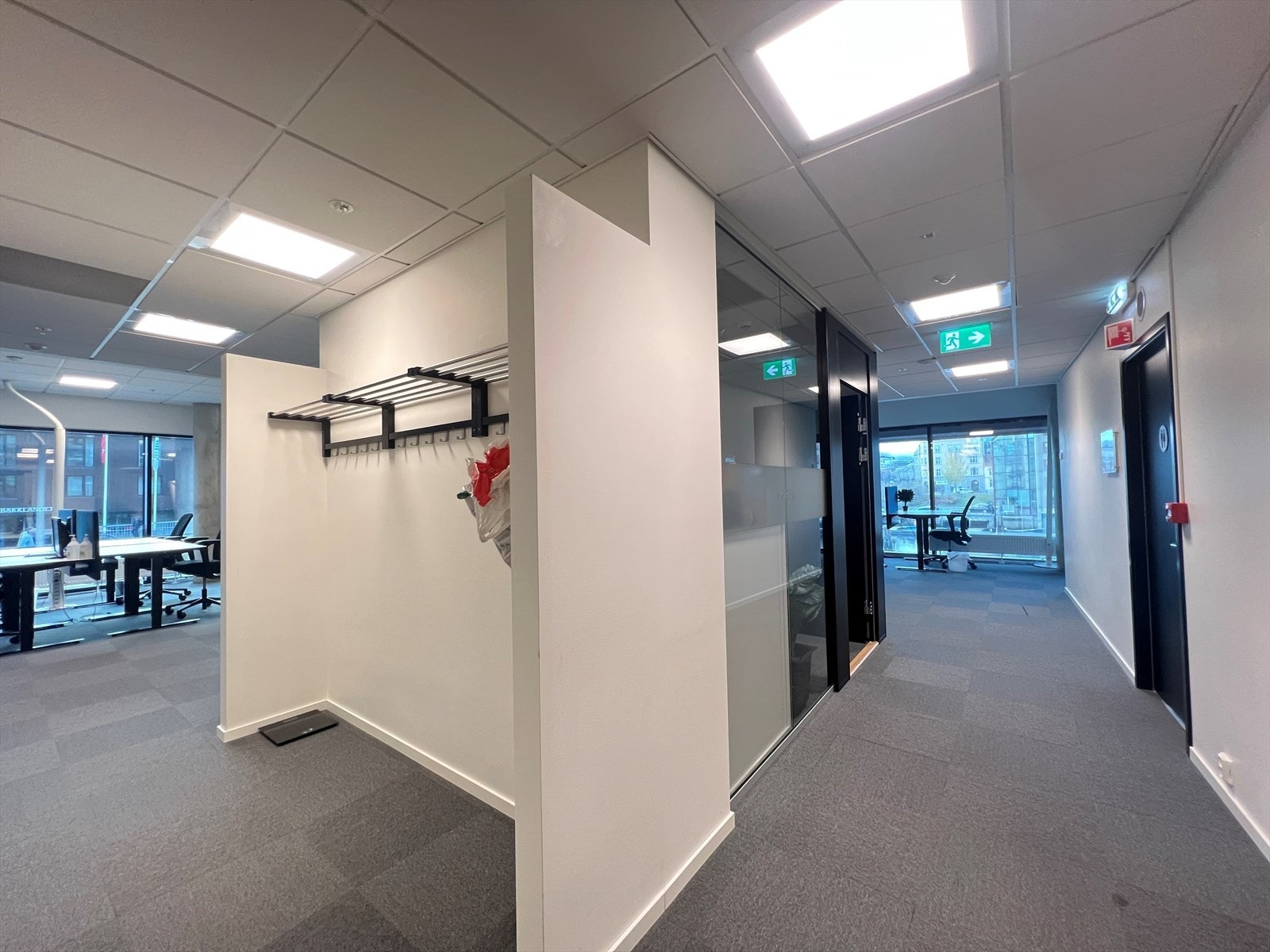 Garderobeløsning hvor en kan henge fra seg yttertøy og kanskje få på seg godtøfler for en behagelig arbeidsdag. Galleribilde