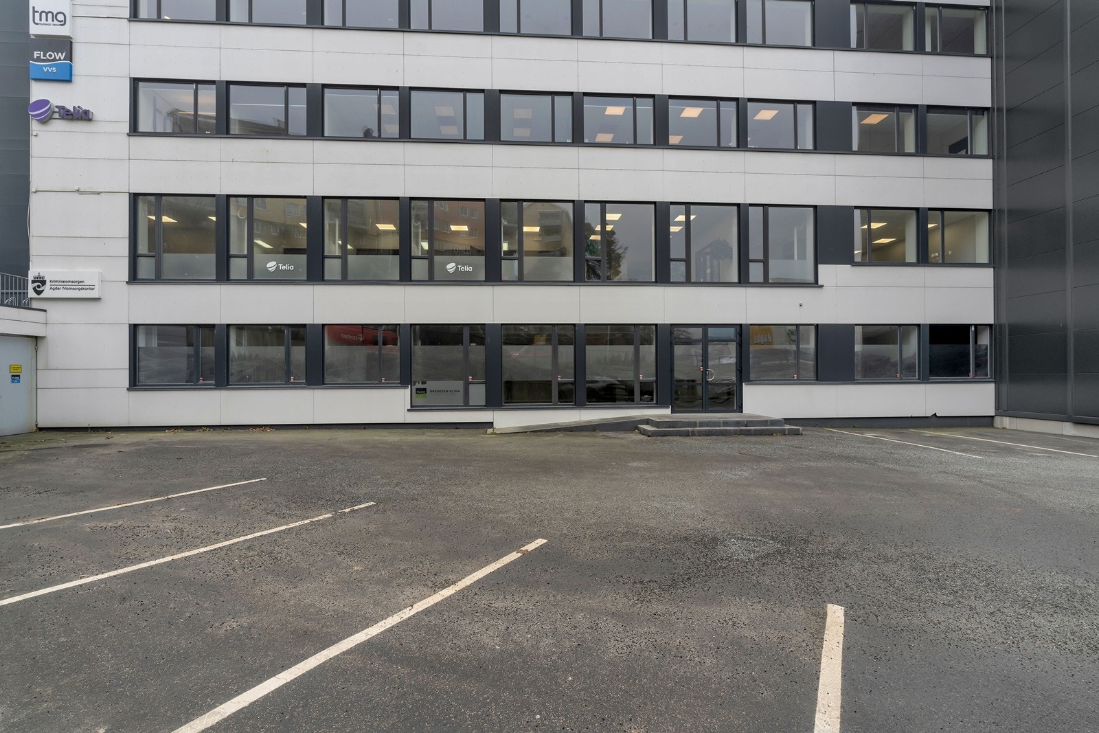 Det er godt med parkeringsareal utenfor bygget. Her er inngangen til ledig butikk/utstillingslokale i første etasje. Galleribilde