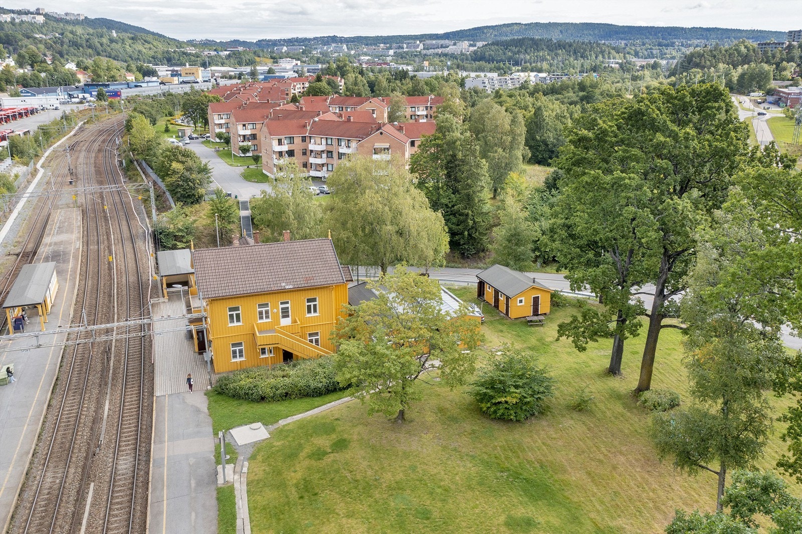 Flat tomt opparbeidet med grøntarealer og trær/busker Galleribilde