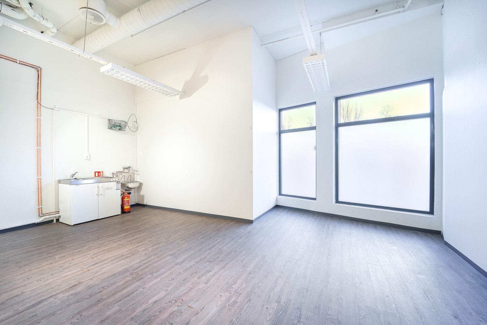 Bakerst i lokalet er det en mini-kjøkken, strømuttak, vann og avløps samt vindu mot gågata. Galleribilde