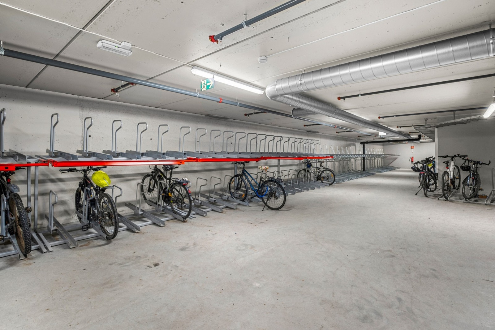 Romslig sykkelparkering i kjeller, med mulighet for å lade elsykkel. Galleribilde