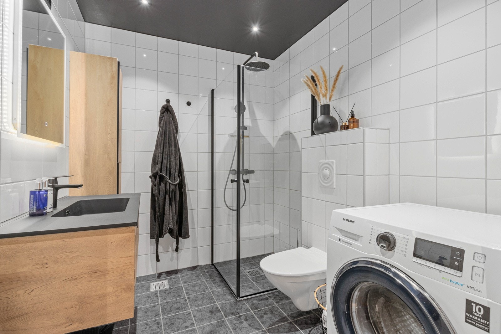 Flislagt bad med opplegg for vaskemaskin og tørketrommel. Galleribilde