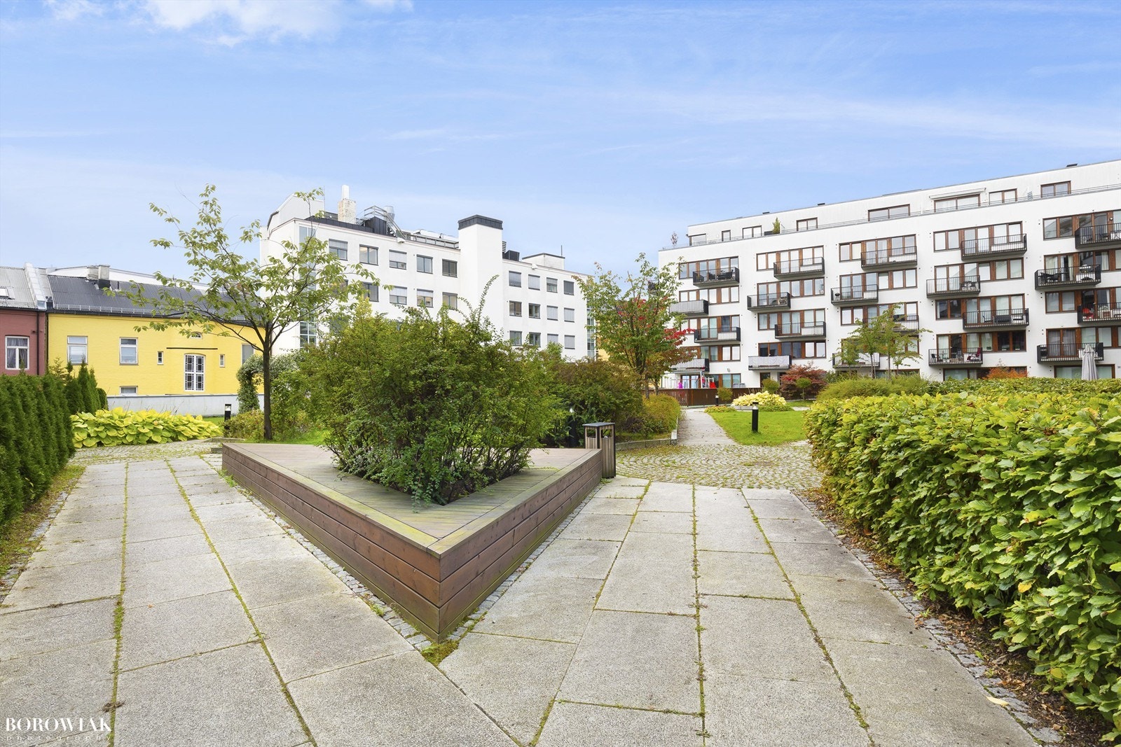 Sameiet har en frodig og flott felles bakgård med hyggelige sittegrupper, gressplen og beplantning Galleribilde