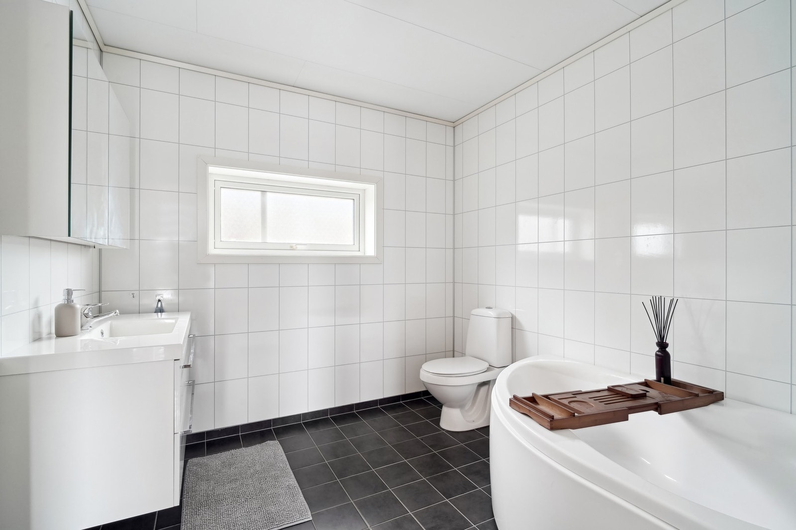 Dette tidløse badet er videre helfliset og har elektriske varmekabler i gulv. Galleribilde