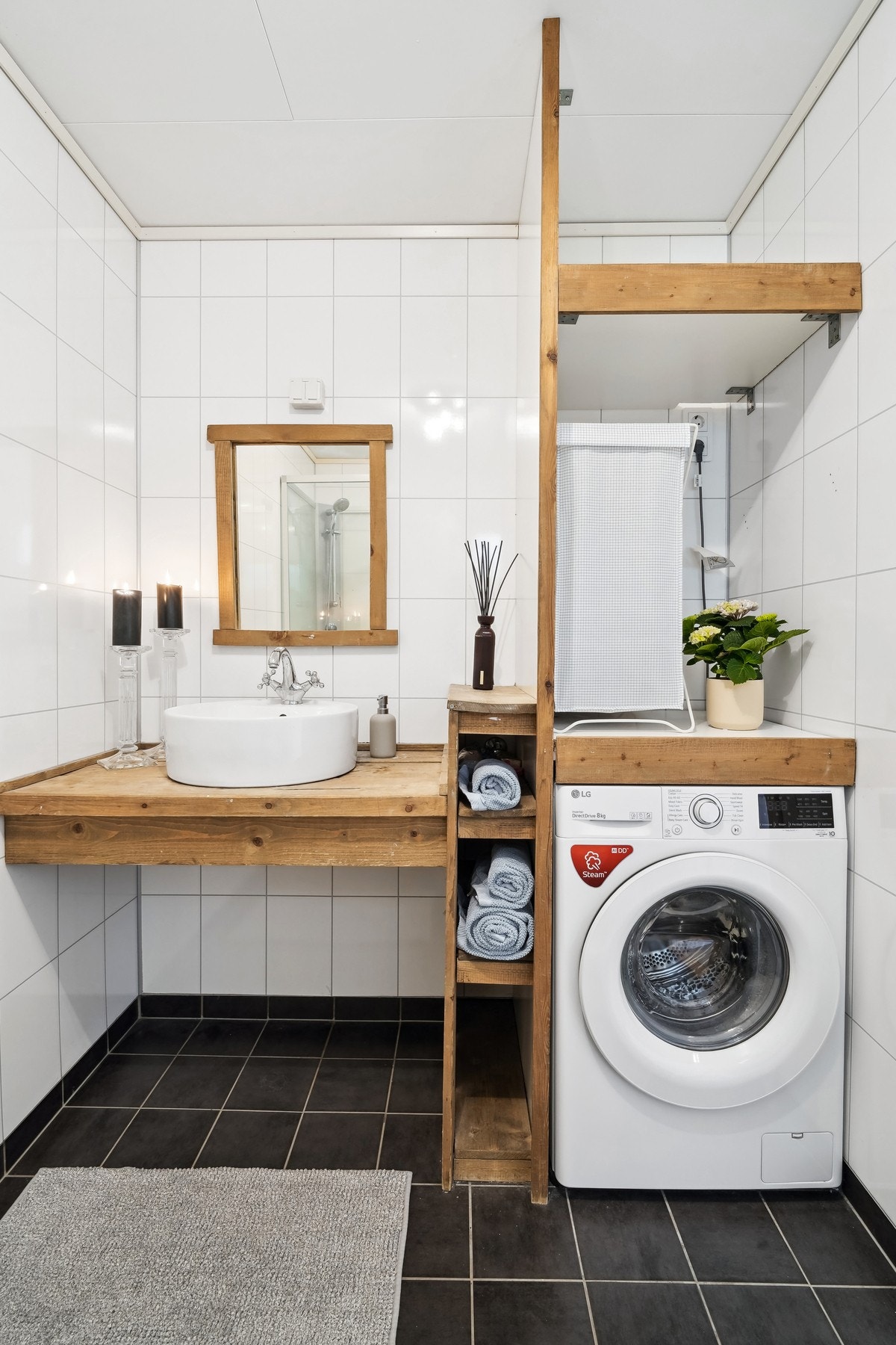 Badet har videre stilfull baderomsinnredning med smarte løsninger, her får du både opplegg for vaskemaskin og tørketrommel samt praktisk oppbevaring for håndklær. Galleribilde