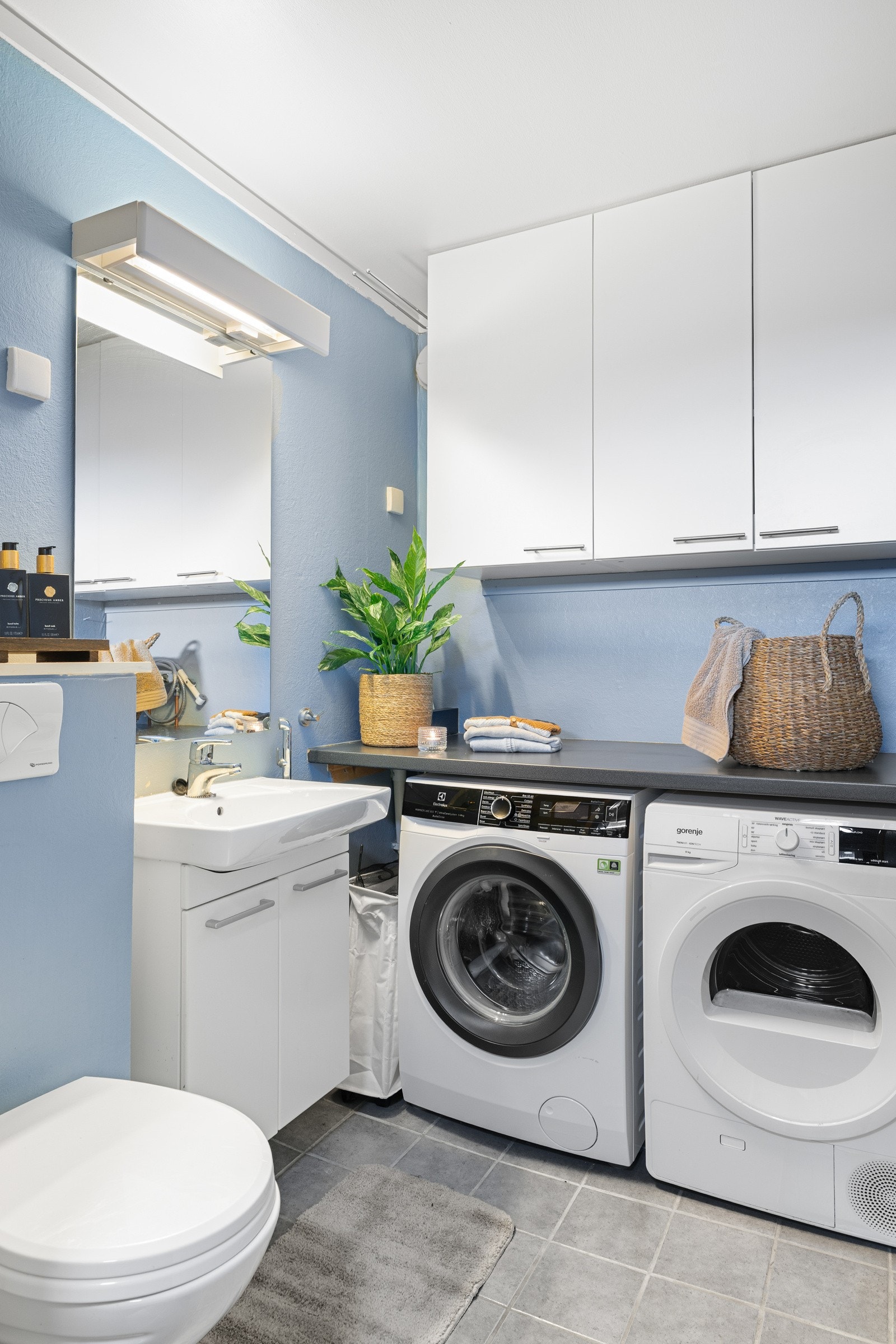 Vegg i vegg med entréen har man et praktisk vaskerom. Innredet med toalett, flere skap, en lys baderomsinnredning samt plass for vaskemaskin og tørketrommel. Galleribilde