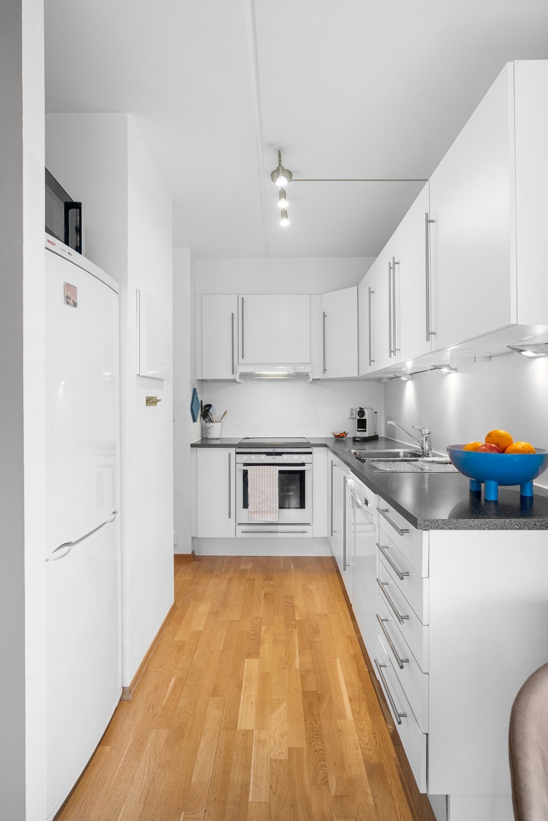 Forøvrig er innredning holdt i et tidløst fargevalg med slette fronter, og mørk benkeplate med kjøkkenkum og avrenningsfelt. Galleribilde