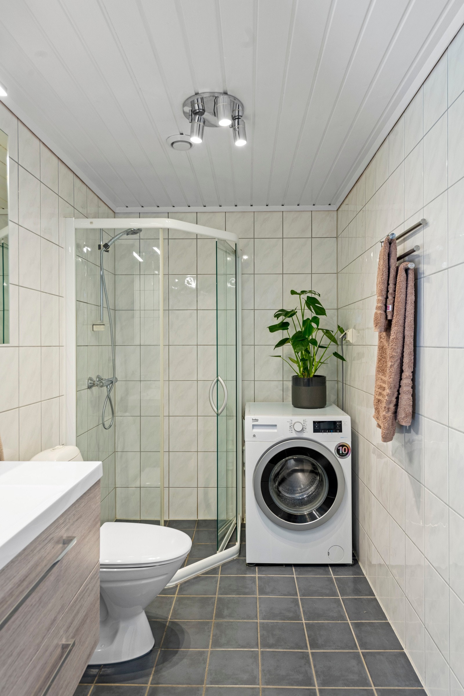Innredet med servantinnredning, dusjhjørne, opplegg fir vaskemaskin og wc. Galleribilde