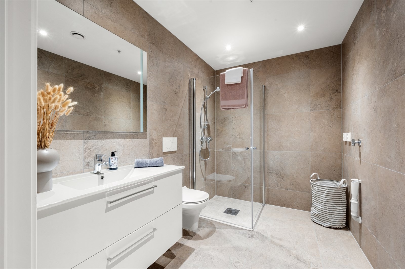 Separat bad/wc/vaskerom. God standard med fliser i storformat og delikate fargevalg Galleribilde