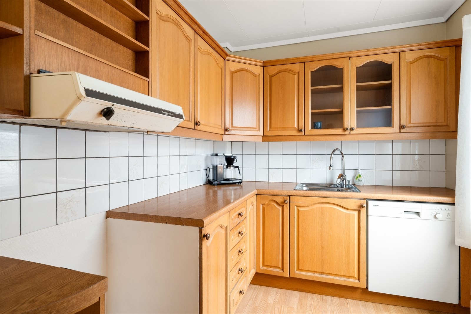 Det er fliser på vegg og laminat benkeplate. Galleribilde