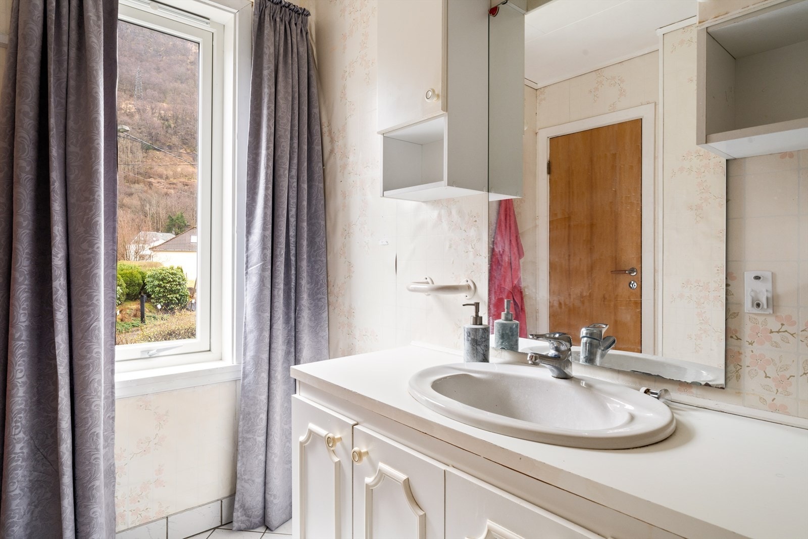 Badet har fliser på gulv og baderomstapet på vegger. Galleribilde