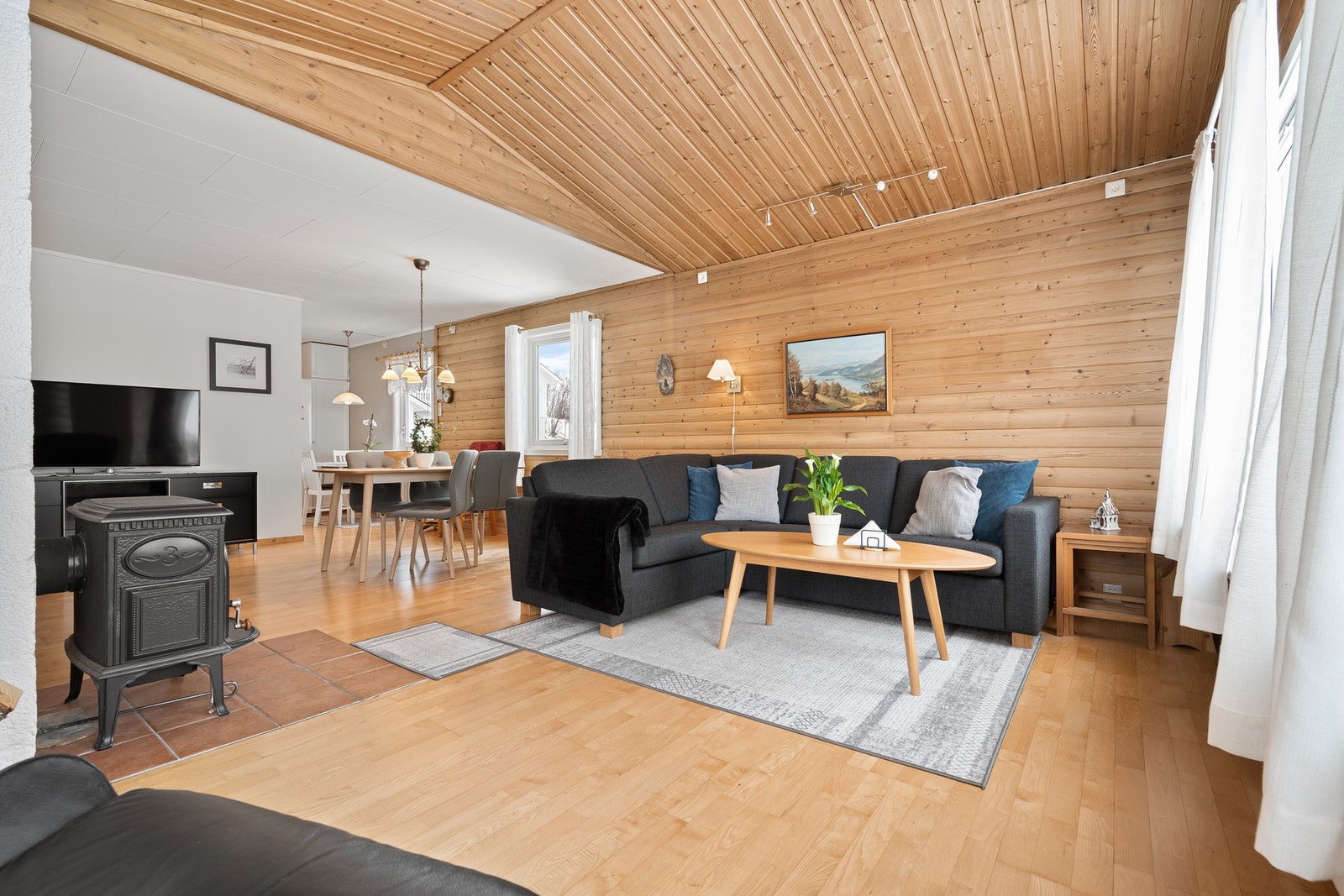 Velkommen inn i stuen! Den gode takhøyden sammen med innslippet av naturlig lys gir umiddelbart en god romfølelse Galleribilde