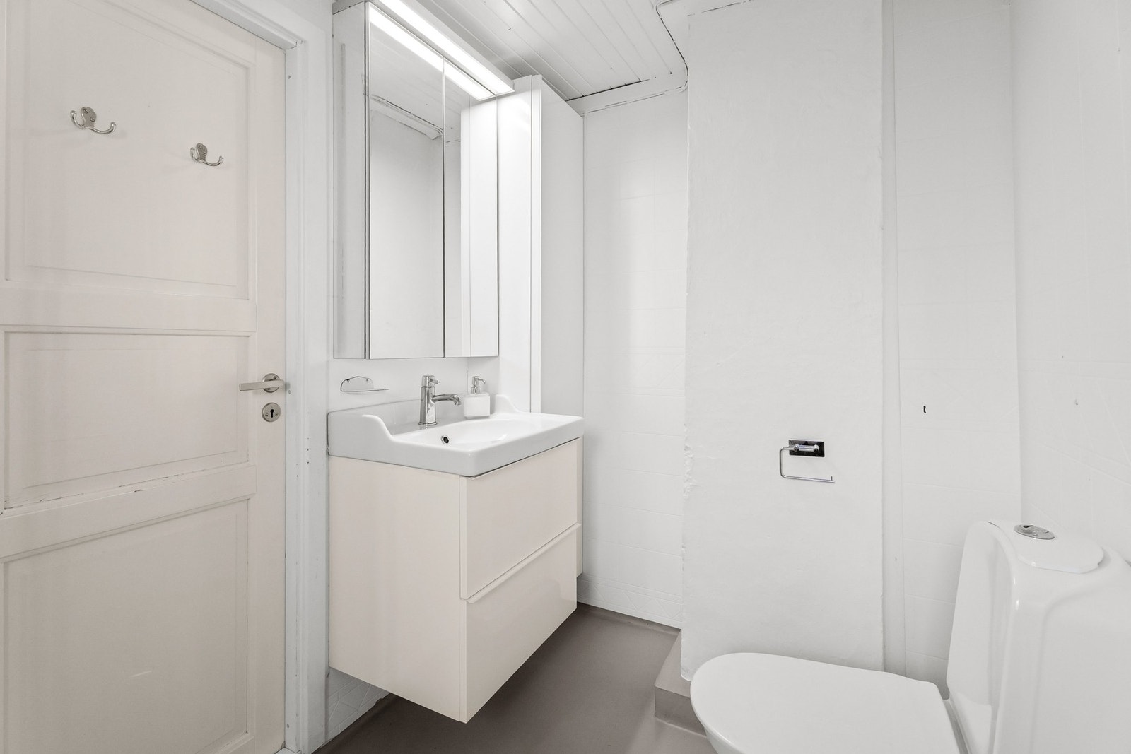 Badet er innredet med servantskap, dusjkabinet og WC. Galleribilde