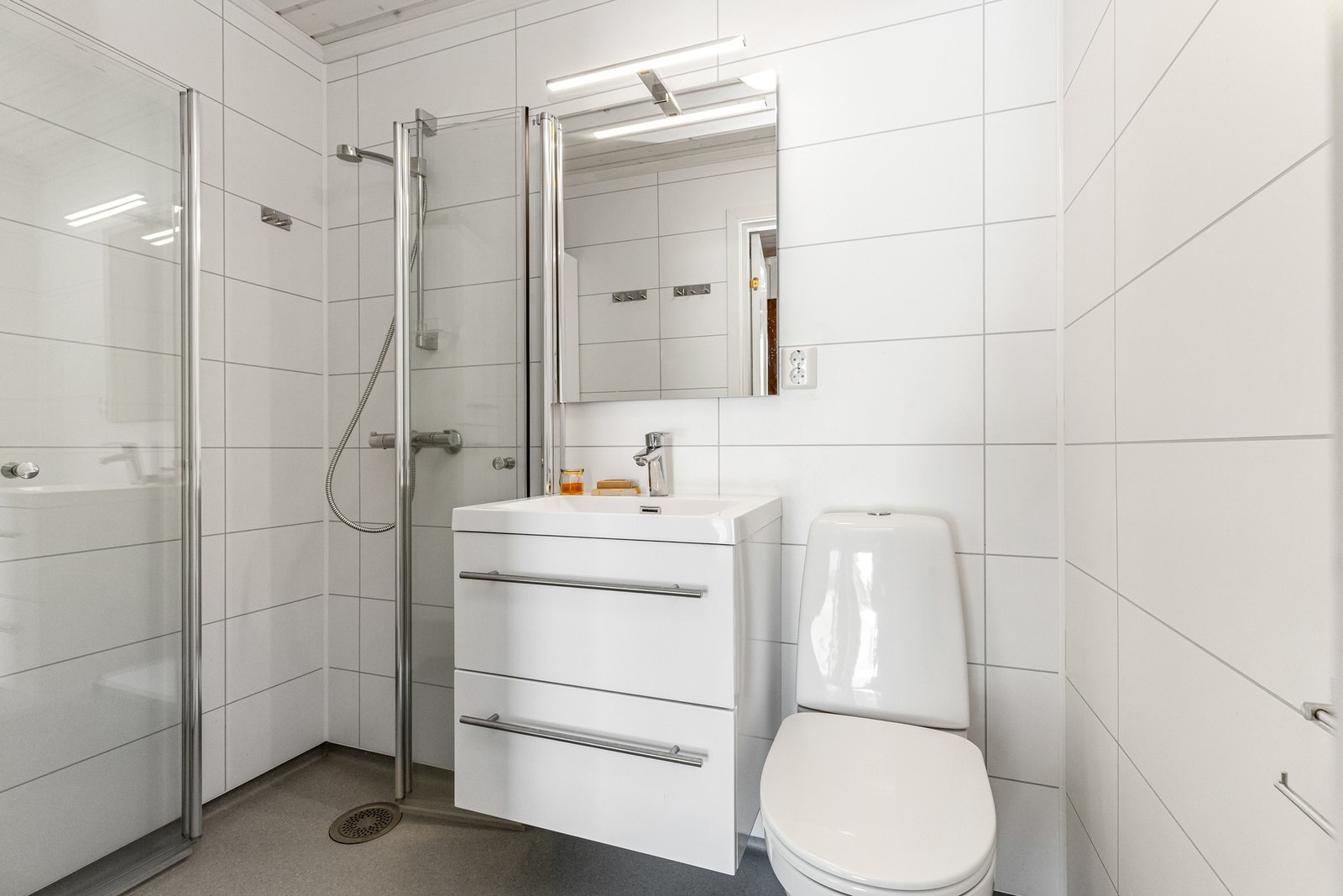 Badet har belegg på gulv og våtromsplater på vegg Galleribilde