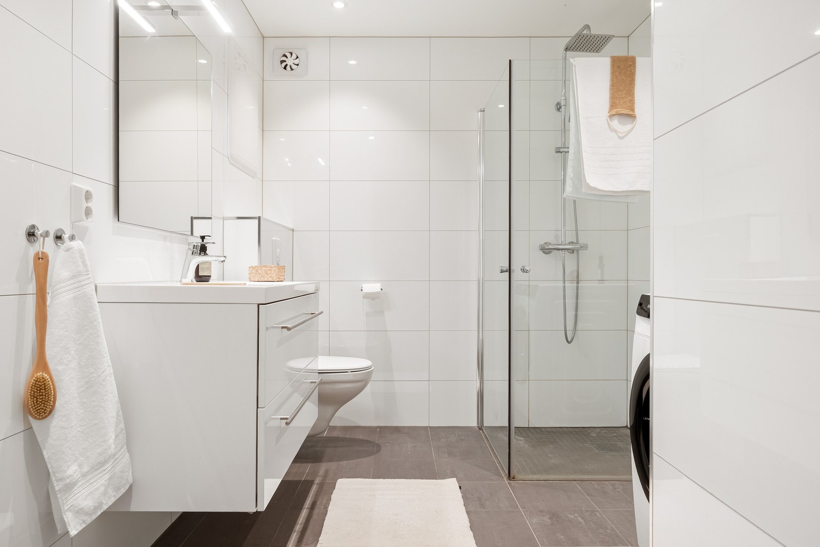 Badet er helfliset og rommet måler ca. 6 kvm. Det er varmekabler i gulv samt spotter i taket, som både er praktiske og stilrene. Galleribilde