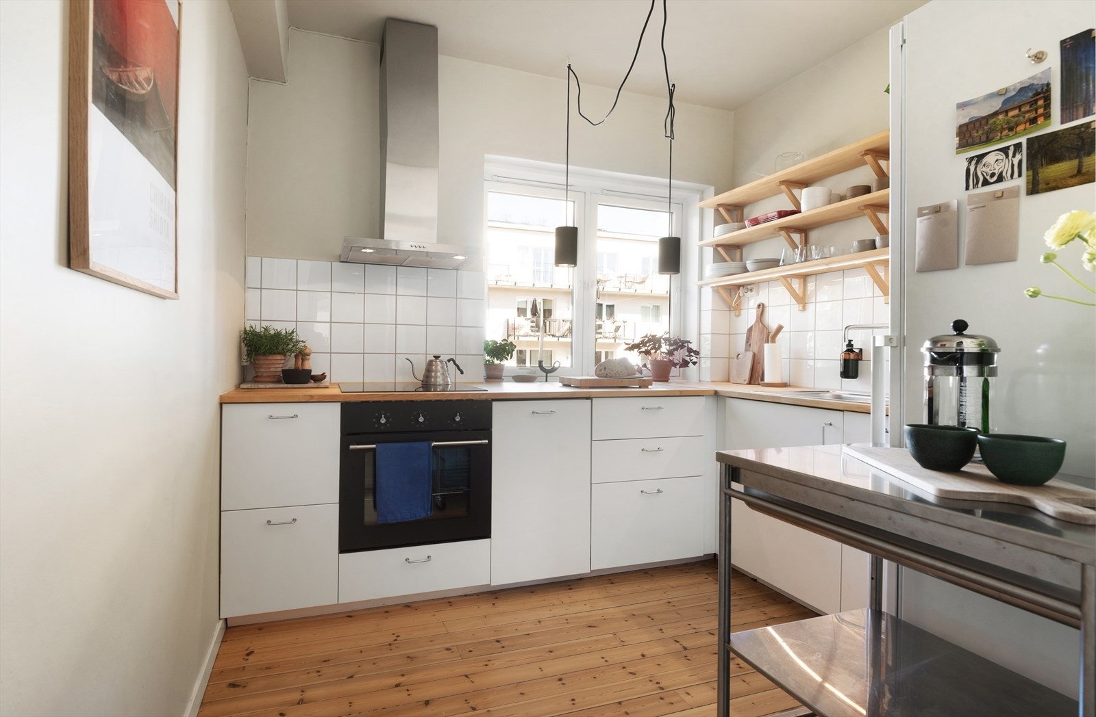 Lyst og pent IKEA-kjøkken fra 2015 med glatte fronter og heltre benkeplate. Galleribilde