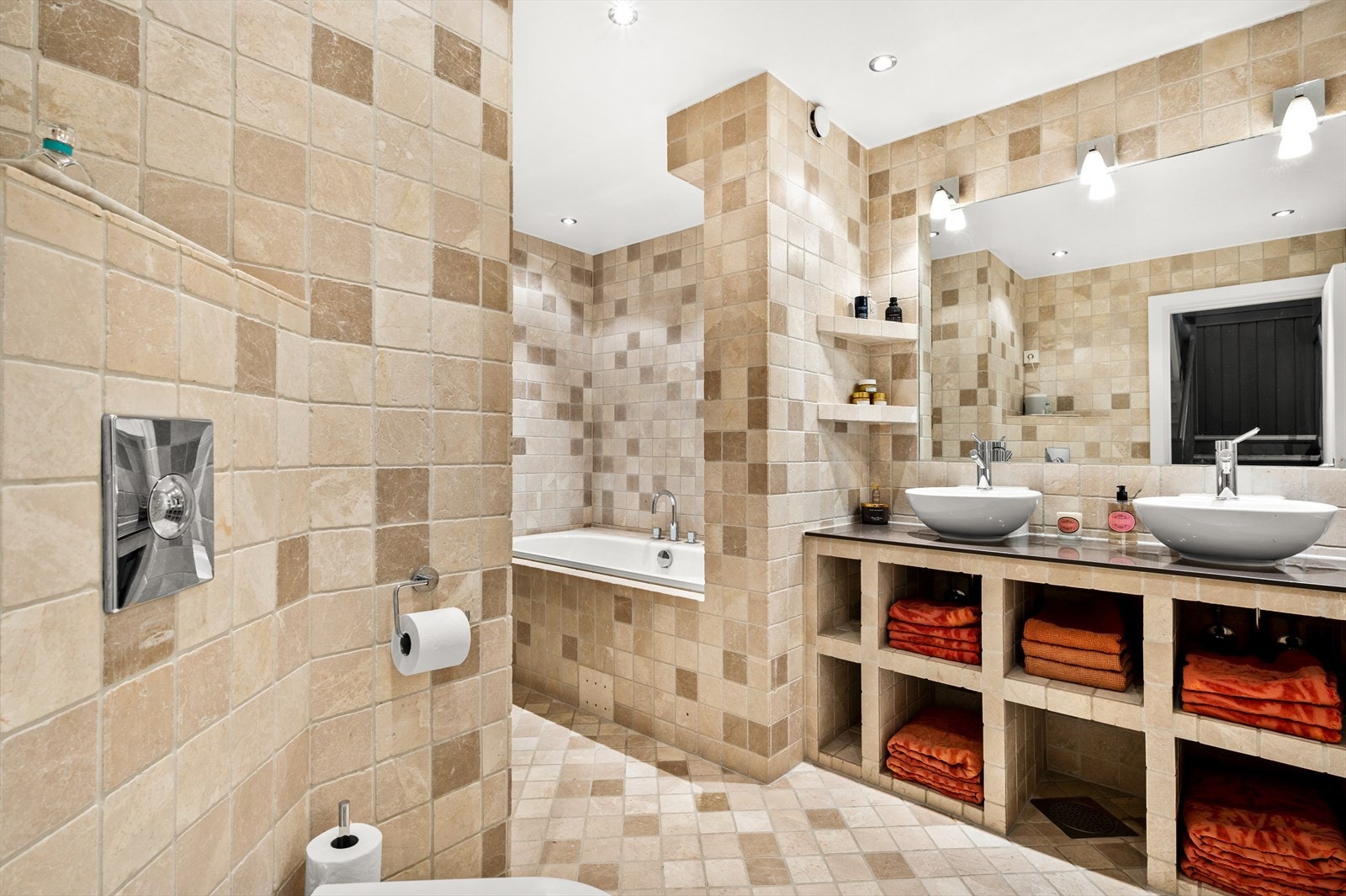 Flislagte vegger og himling med downlights. Dusjhjørne med glassvegg og innmurt badekar. Vegghengt toalett. Galleribilde