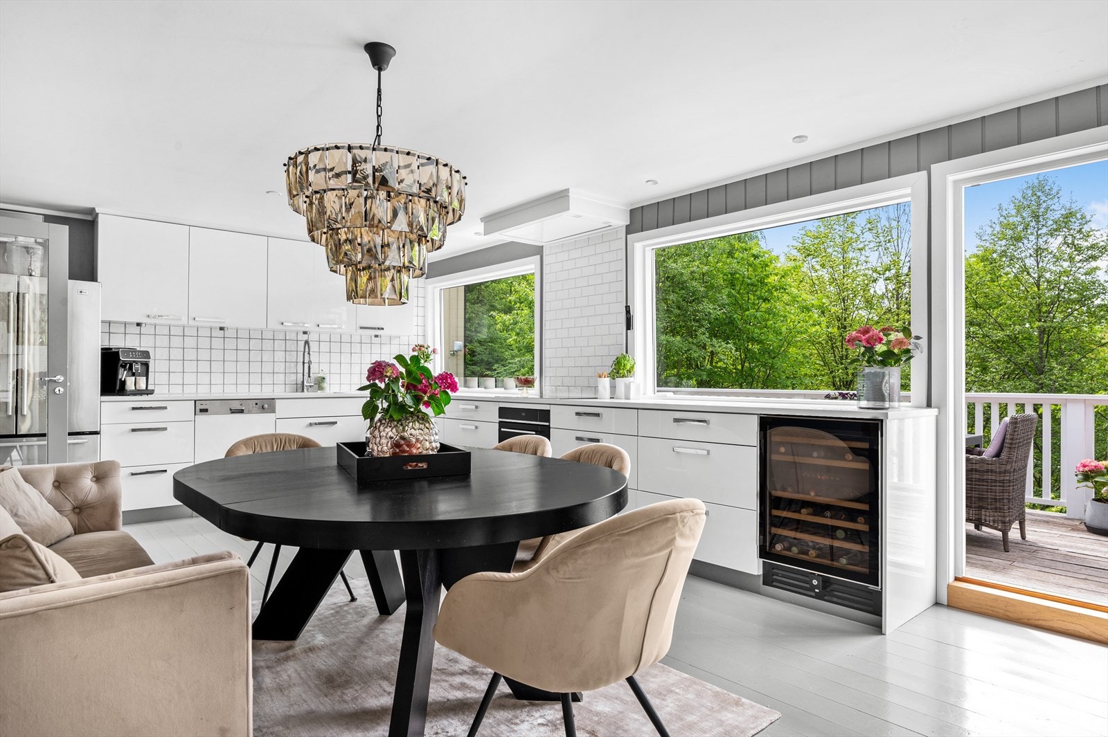 Pent, lyst kjøkken med slette fronter, benkeplate av kompositt og integrerte hvitevarer. Galleribilde