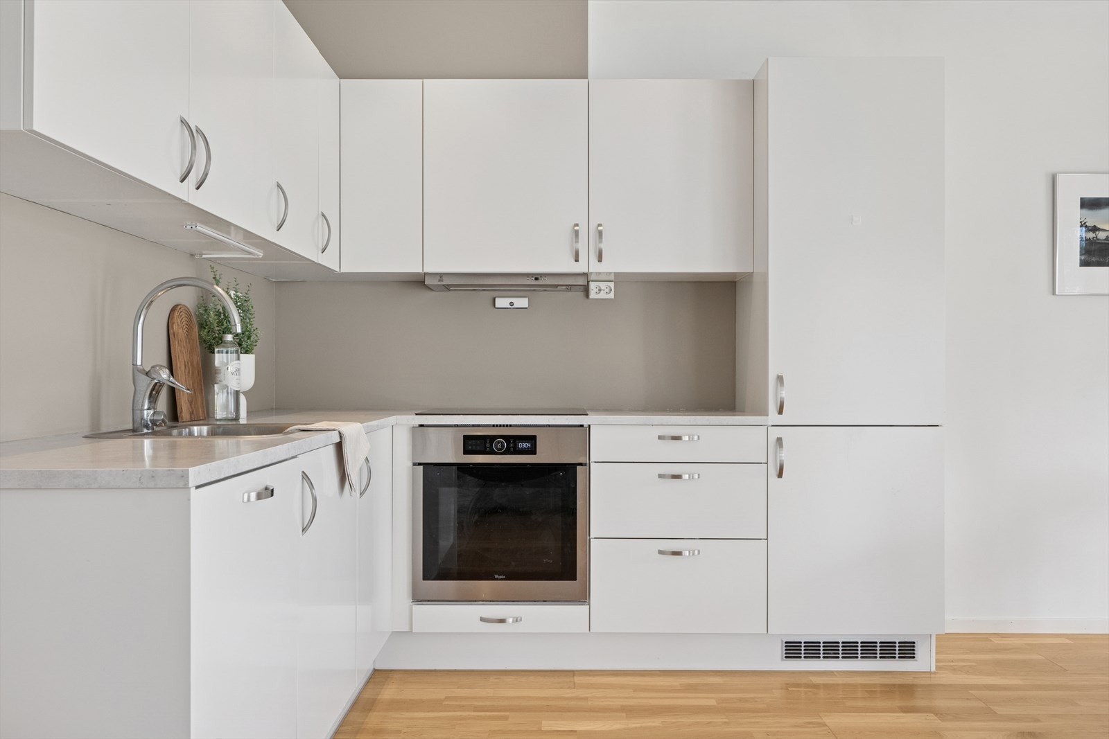 Kjøkkenet framstår som lyst med moderne overflater og nøytrale farger. Galleribilde