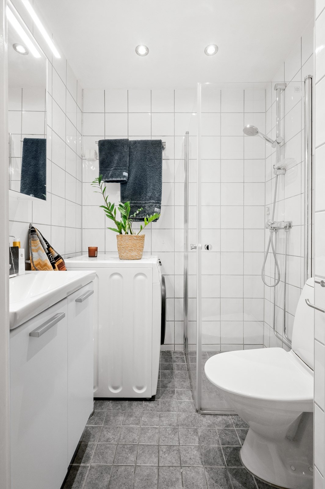 Innredningen består av servant på innredning og speilskap med belysning over servant. Videre er det dusjhjørne med svingbare glassdører og gulvstående toalett. Opplegg for vaskemaskin og naturlig avtrekk. Galleribilde