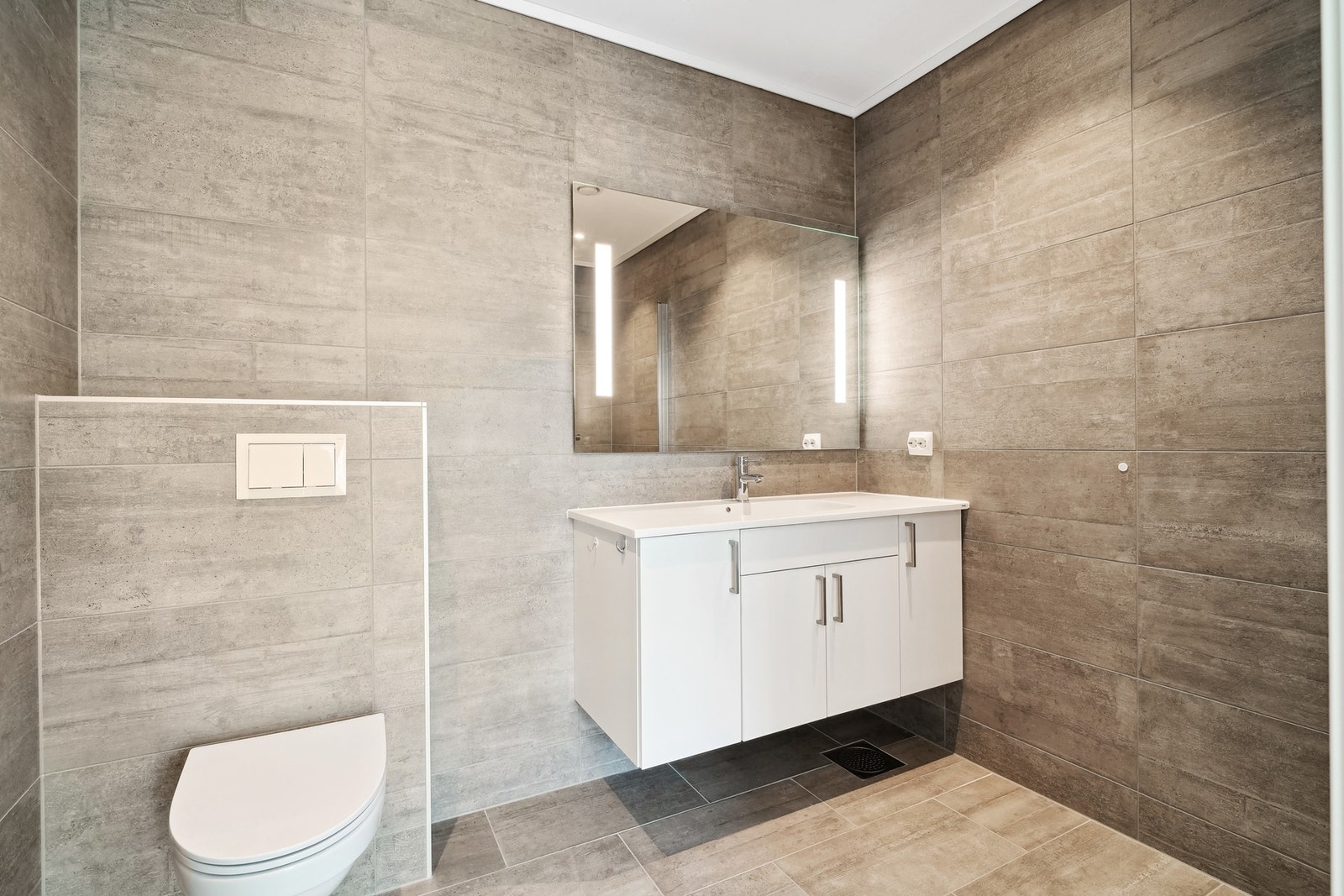 Moderne design, stor speilflate med innfelt lys, pen innredning og vegghengt toalett. Galleribilde