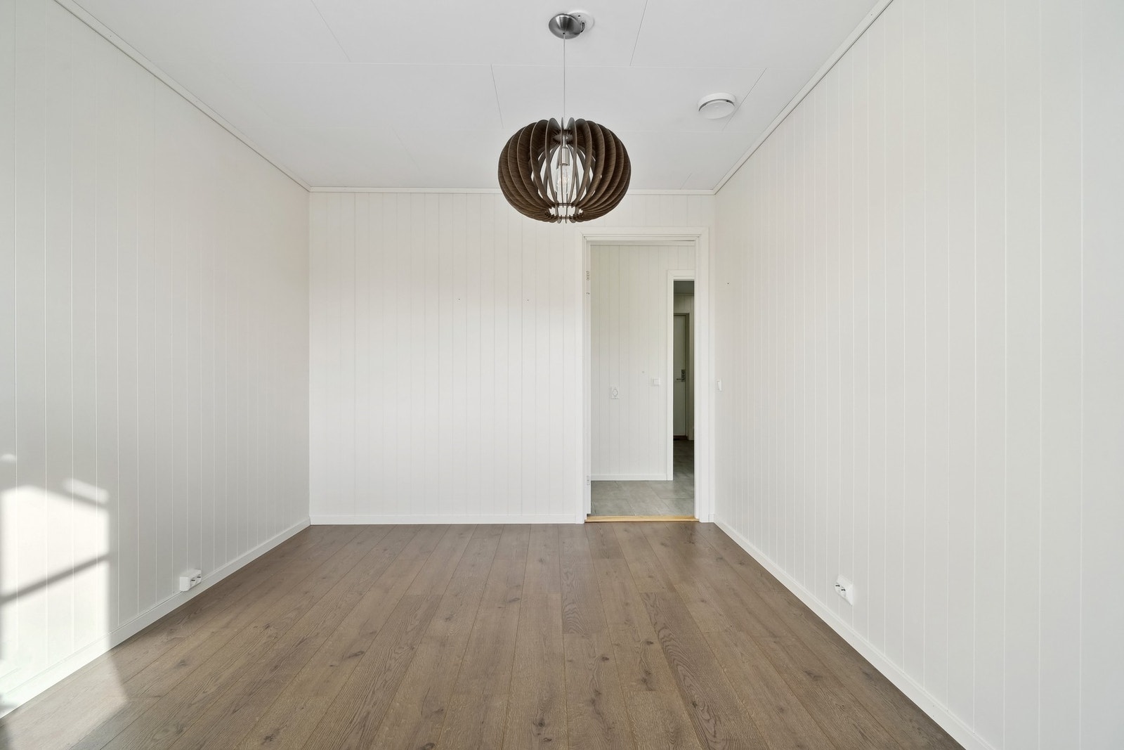 Laminatgulv og lyse veggflater. Galleribilde