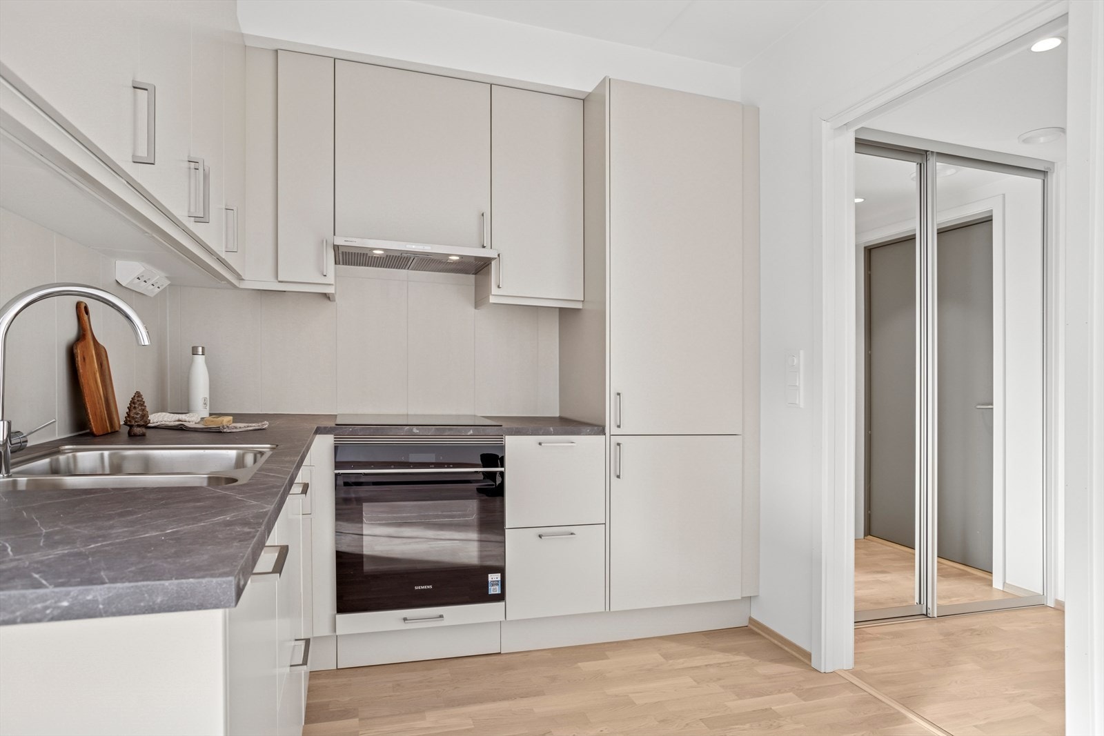 Videre kommer man inn i en åpen stue/kjøkkenløsning hvor kjøkken ligger naturlig adskilt fra stuen. Galleribilde