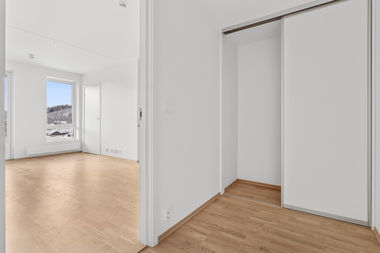 Fra stue/kjøkken har man en praktisk mellomgang med skyvedørsgarderobe og plass til feks en kontorpult eller mer oppbevaring. Galleribilde