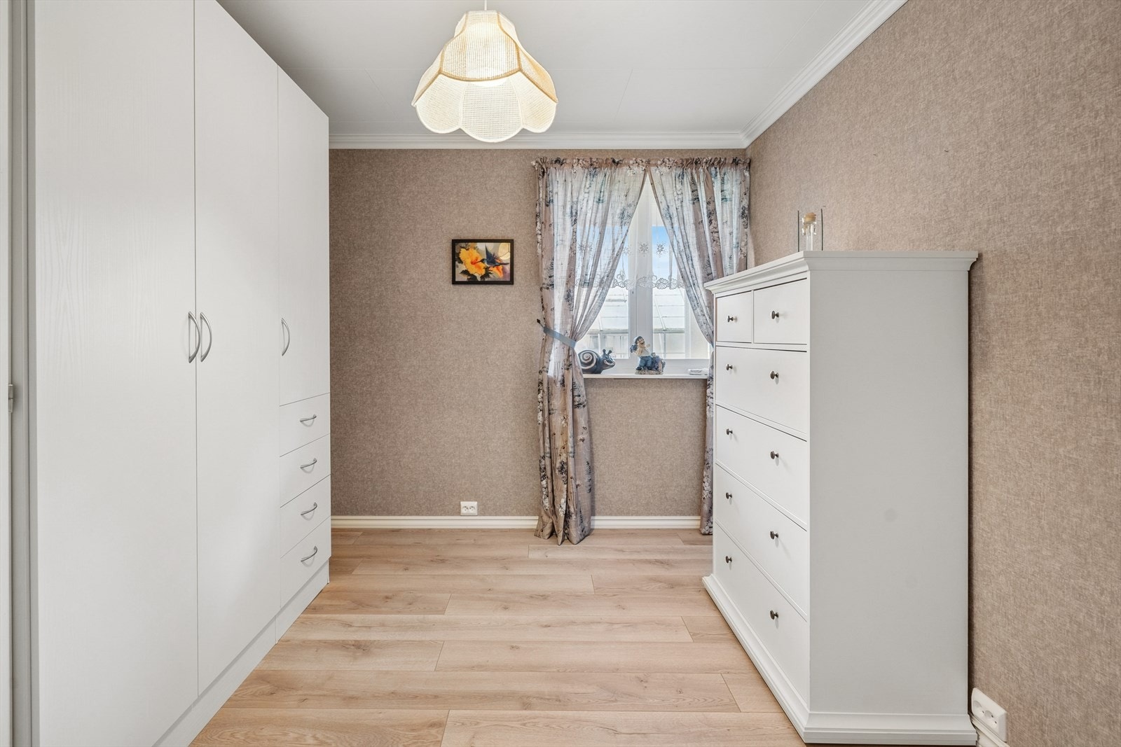 Lyst soverom med god plass til stor seng, nattbord og garderobeløsning. Galleribilde