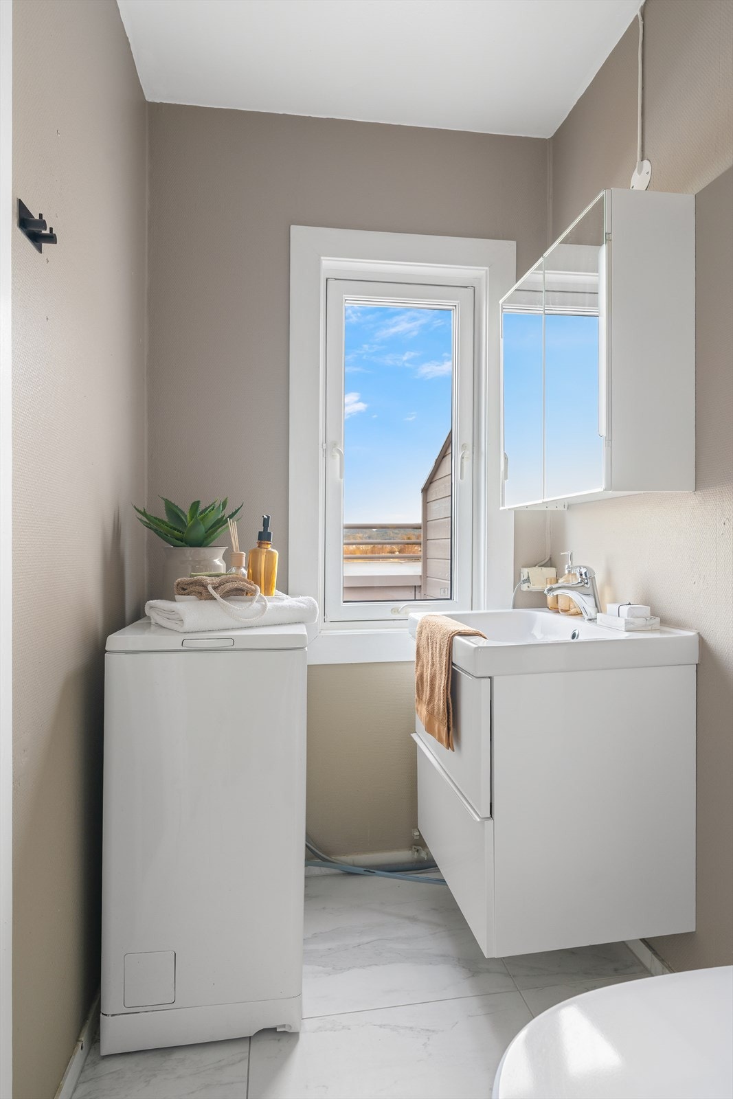 Lyst og pent baderom på 3 kvm. Badet har fliser på gulv og varmekabler. Galleribilde