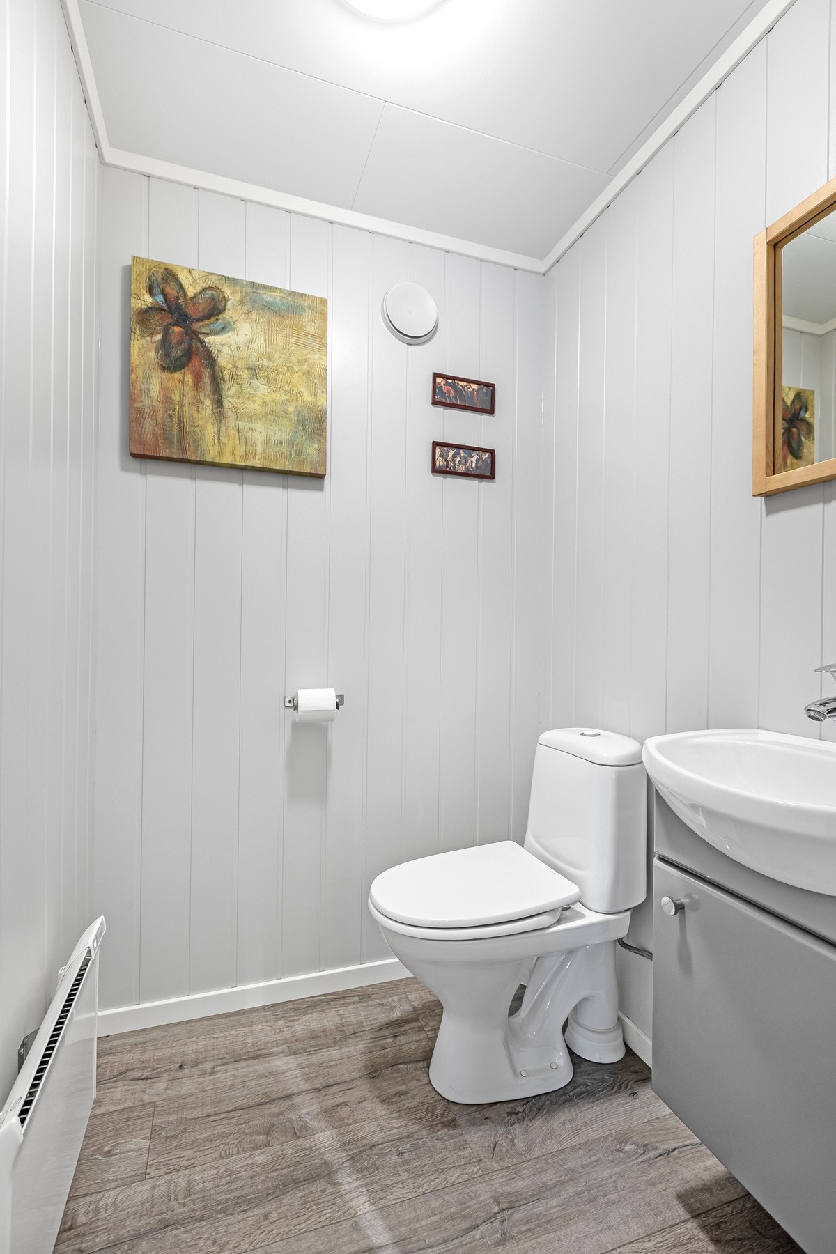 Separat wc- rom med gulvmontert wc samt innredning med nedfelt servant. Galleribilde