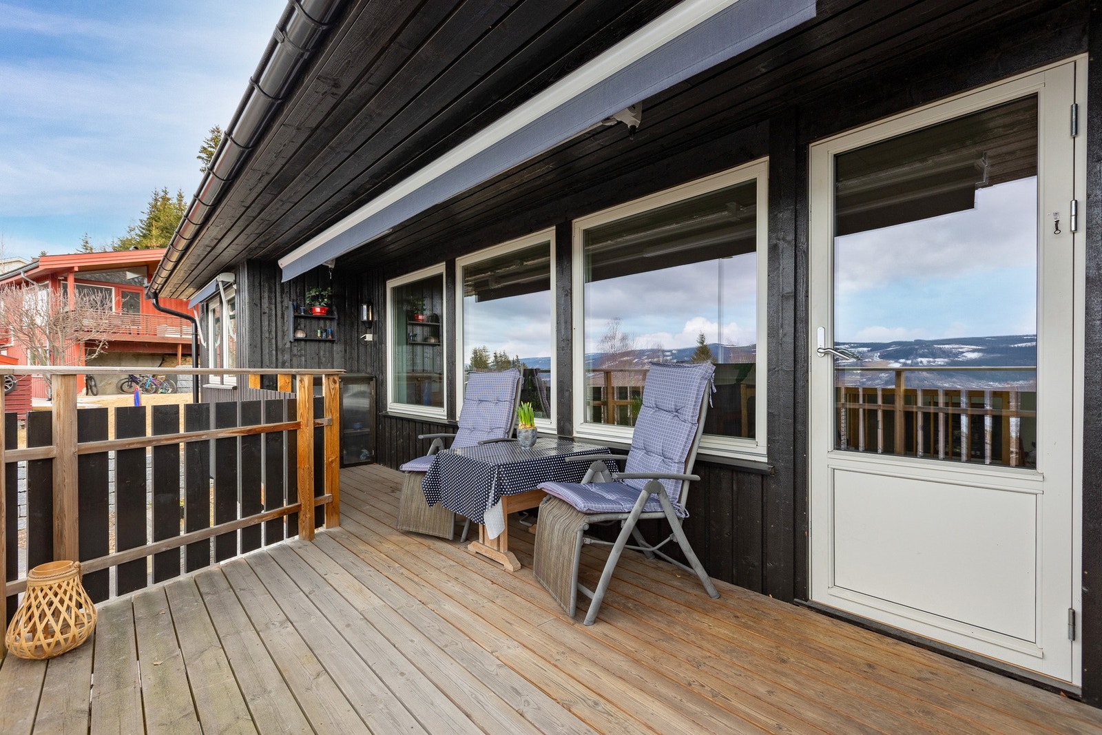 Utgang fra stue til dels overbygget veranda. Solrik uteplass med terrassemarkise. Galleribilde