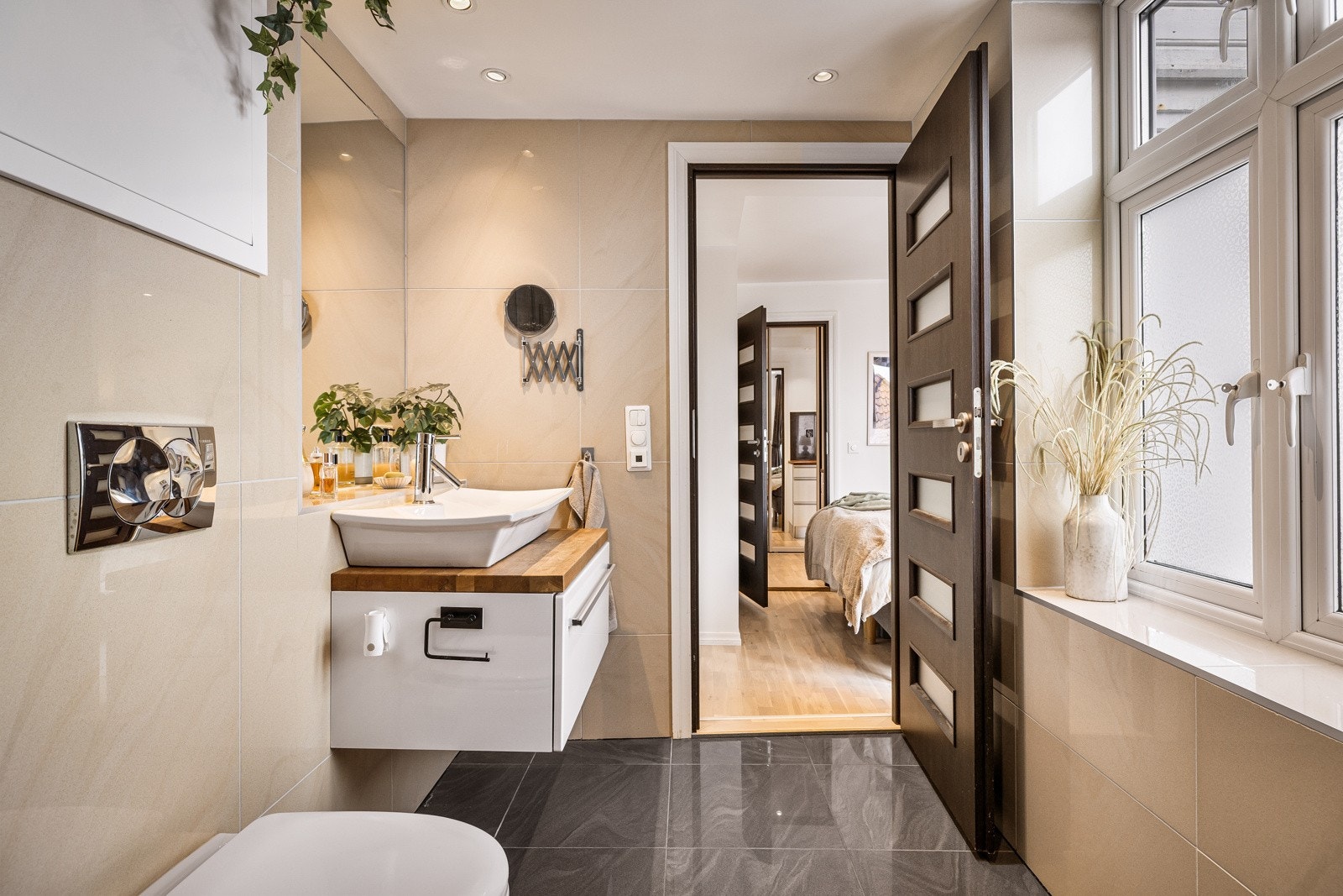 - Badet er innredet med toalett, dusjnisje med glassdører, møblement med frittstående servant, speil og belysning - Galleribilde