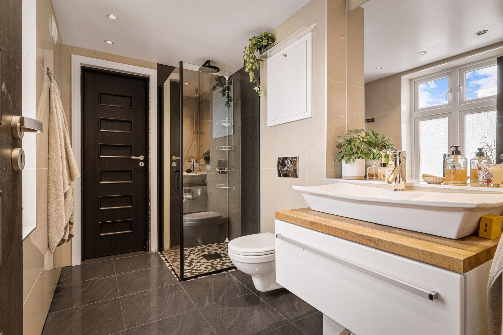 - Badet er helfliset og har mosaikkfliser i dusjsone - Galleribilde