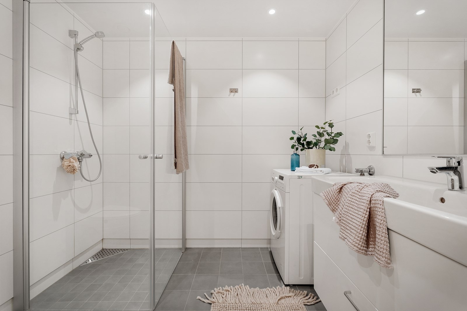 Helfliset baderom med downlights og opplegg for vaskemaskin Galleribilde