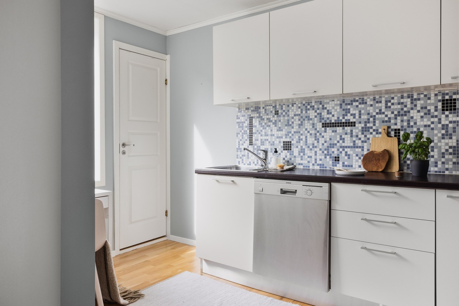 Kjøkkenet finner du i en delvis åpen løsning med stuen. Det er slette fronter og laminat benkeplate med nedfelt vask av stål. Galleribilde