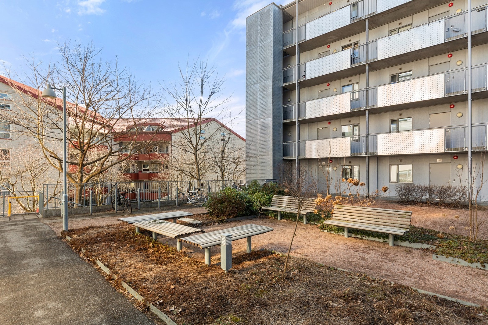 Gårdsrommet har forøvrig asfalterte internveier, plenarealer, prydbusker og blomsterbed, samt hellebelagte partier, sittegrupper og benker Galleribilde