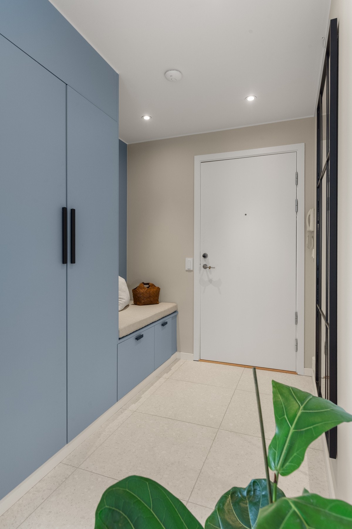 Entréen har et praktisk plassbygd garderobeskap og benk med skuffer, som gir både god oppbevaringsplass og en komfortabel løsning for påkledning Galleribilde