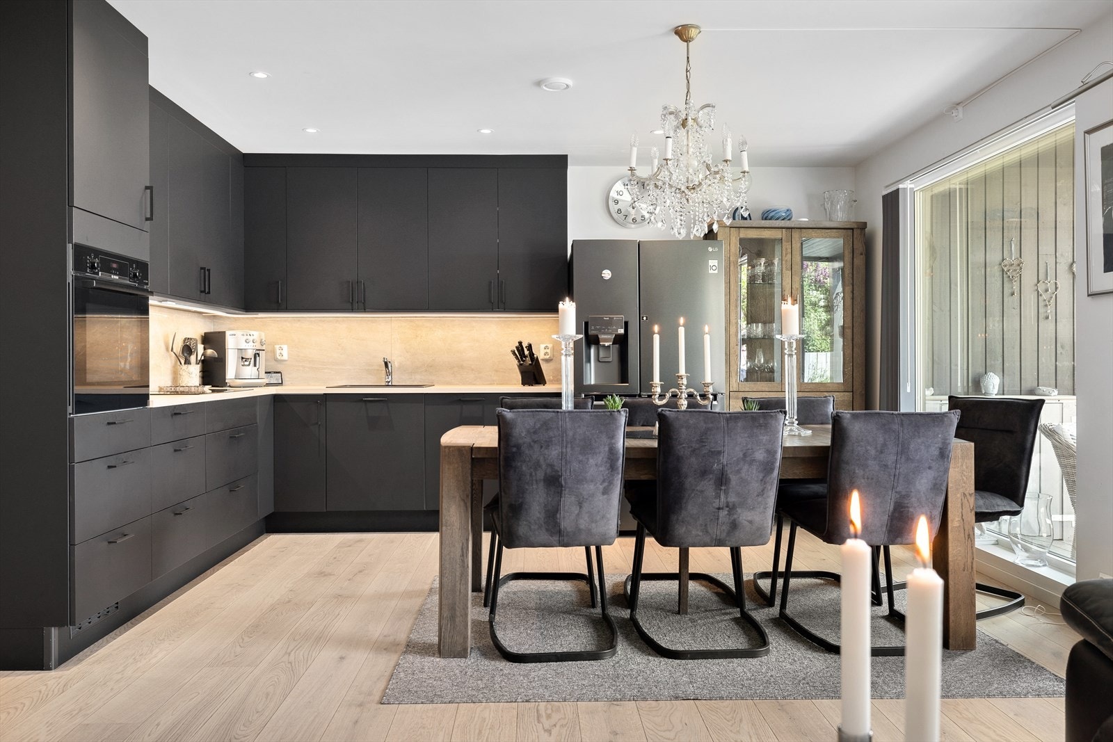 På kjøkkenet er det stilig svart innredning med hvitevarer integrert Galleribilde