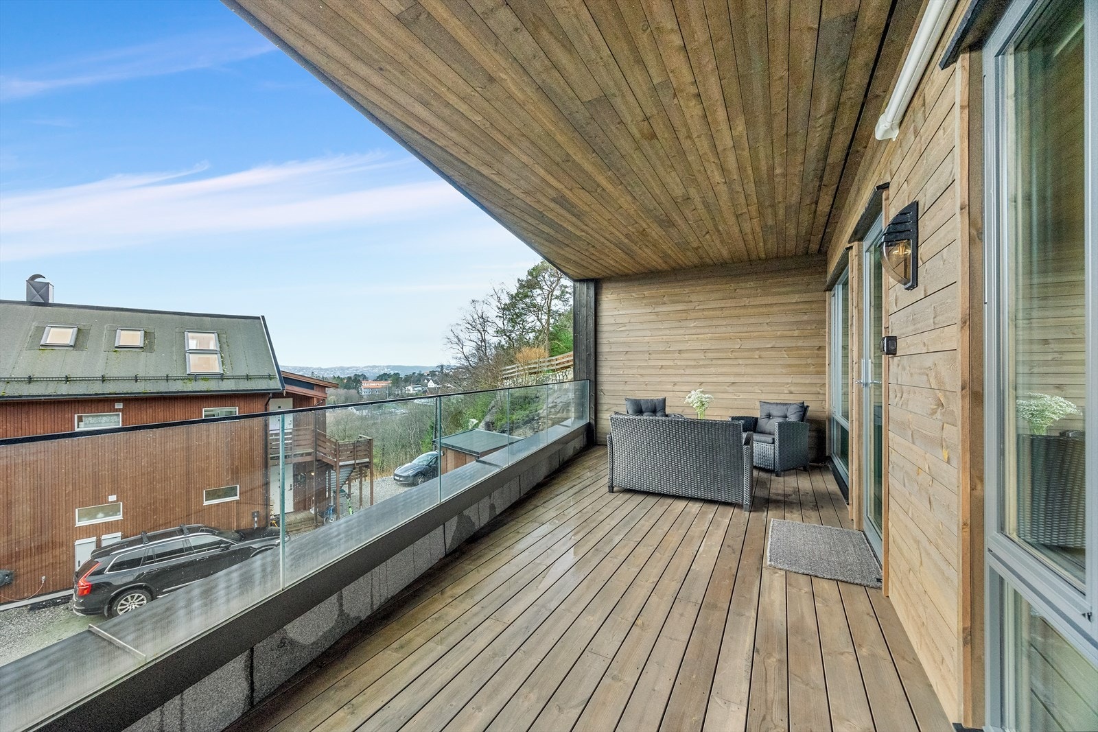 Utgang til en romslig terrasse med lekkert glassrekkverk og meget fine solforhold. Galleribilde