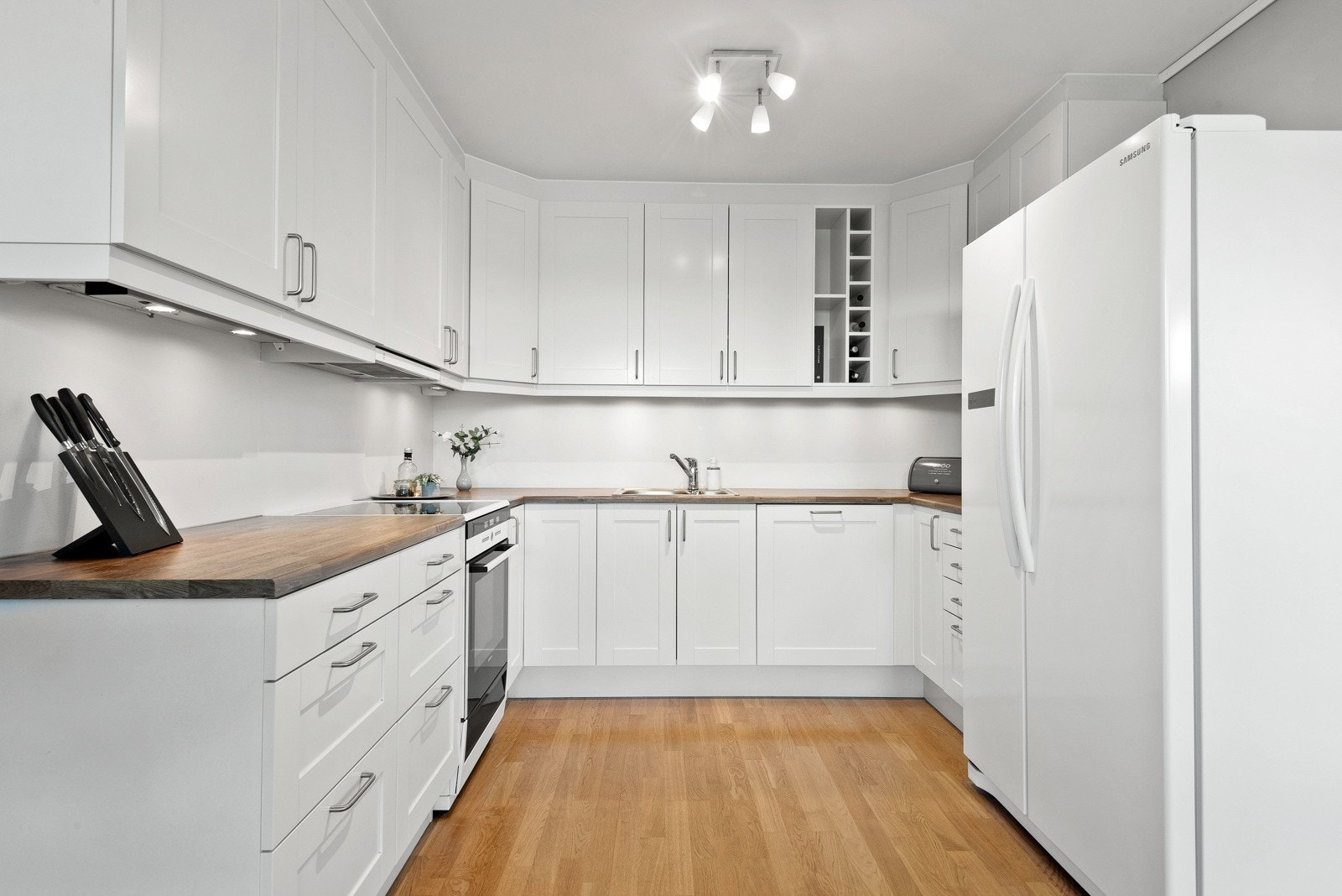 Hvitprofilert kjøkkeninnredning fra Sigdal. Kjøkkenet fremstår som lyst og tidsriktig med profilerte fronter. Alle hvitevarer medfølger. Galleribilde